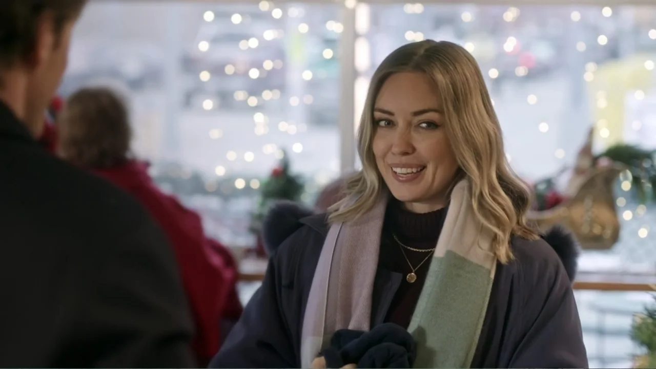 Peppermint and Postcards (2023) movie still: medium — An interior cafe space with blurred bokeh lights visible through the window panes. A woman in…