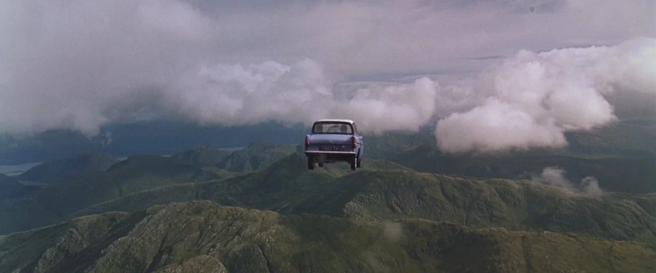 Harry Potter and the Chamber of Secrets (2002) movie still: wide — An aerial view shows a vast mountain range beneath a thick layer of clouds. A…