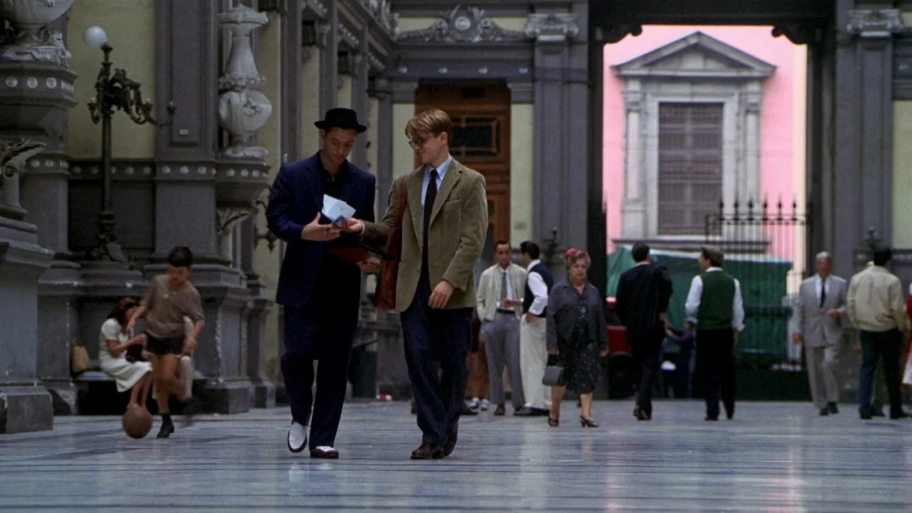 The Talented Mr. Ripley (1999) movie still: fullbody — A stone arcade with neoclassical architectural details features people walking on a paved…