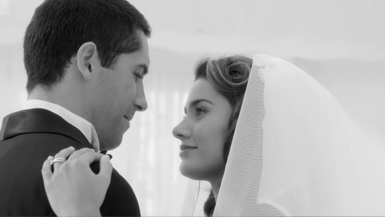 Assassination Games (2011) movie still: medium — A bright wedding ceremony space features the couple facing one another in profile. The man in a…