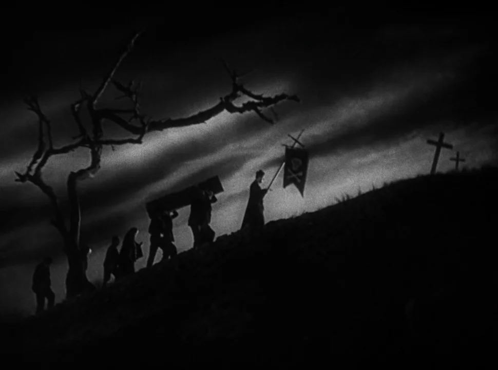 The Bride of Frankenstein (1935) movie still: wide — A group of figures ascends a dark, grassy slope silhouetted against a cloudy sky. One person…