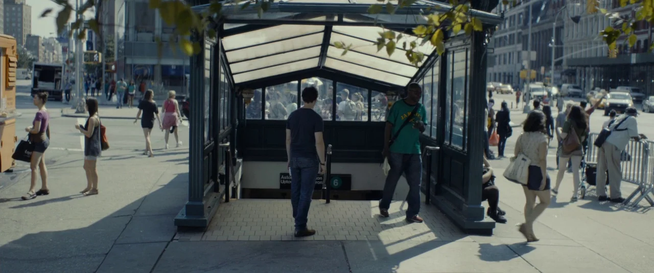 The Disappearance of Eleanor Rigby: Him (2014) movie still: wide — A bustling city sidewalk features a metal-framed subway station entrance at the…