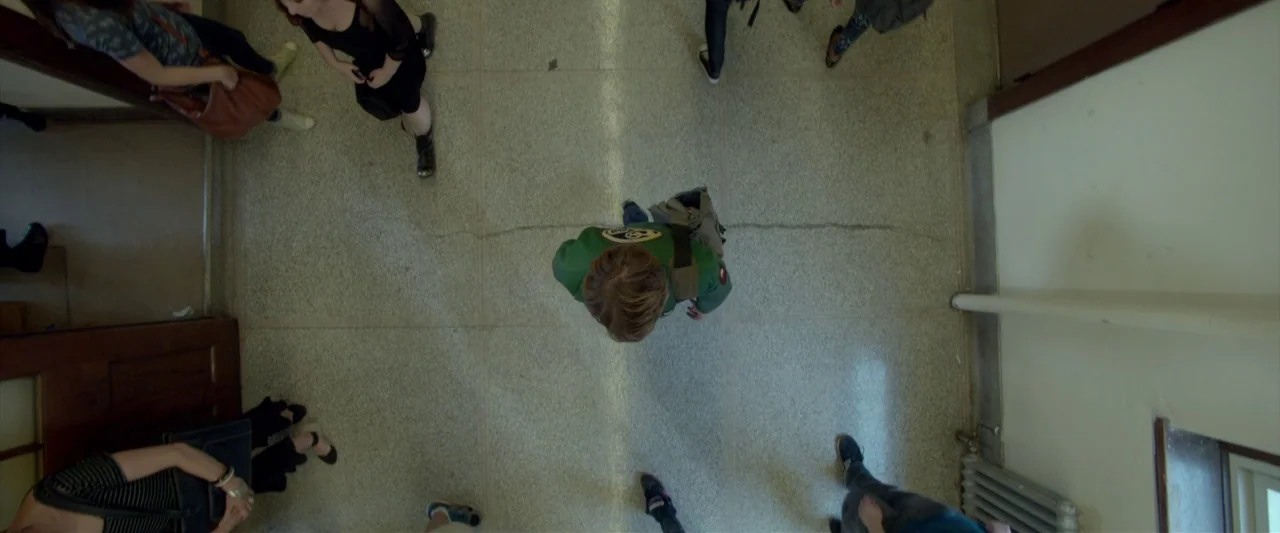Me and Earl and the Dying Girl (2015) movie still: wide — A top-down view of a terrazzo school floor populated by several students in motion. A…