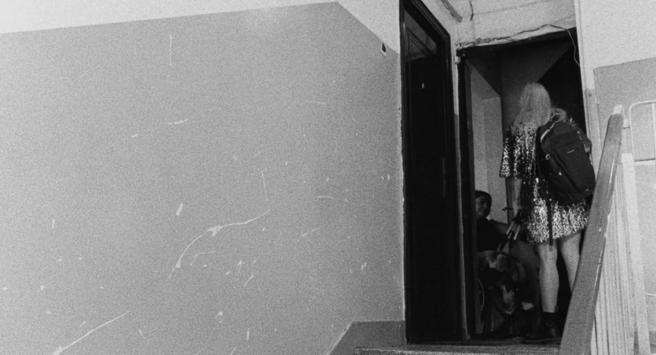 Do Not Expect Too Much from the End of the World (2023) movie still: medium — A stairwell with textured concrete walls leads to an open dark…