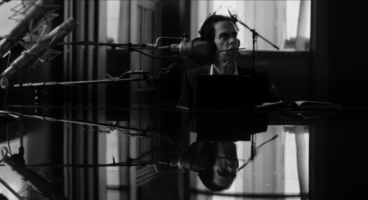 One More Time With Feeling movie still: medium — A dark, modern recording studio environment with high-gloss reflective surfaces and professional…