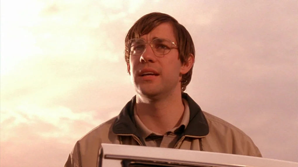 Smiley Face (2007) movie still: medium — A man stands outdoors under a bright, overcast sky during late afternoon. He gazes off-screen with a…