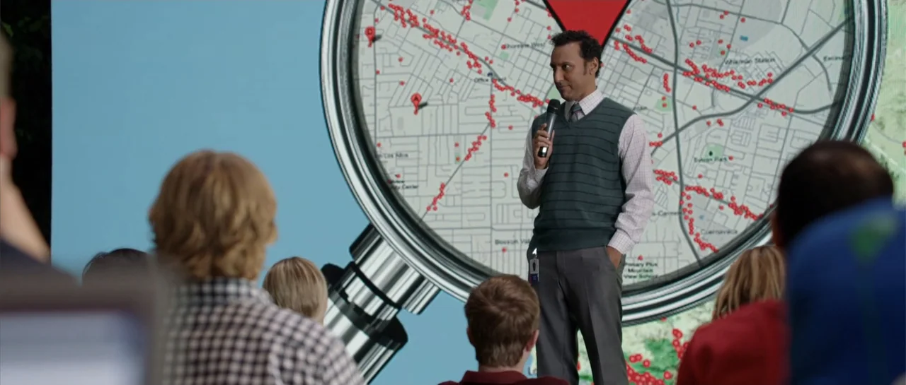 The Internship (2013) movie still: medium — A modern presentation space features a massive digital screen displaying a map with red markers. A man…