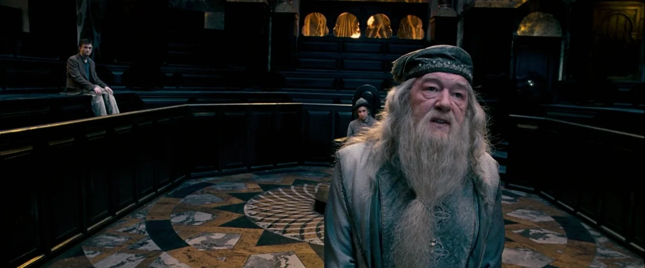 Harry Potter & The Order of the Phoenix (2007) movie still: medium — A dark stone circular chamber features tiered wooden benches and a patterned…