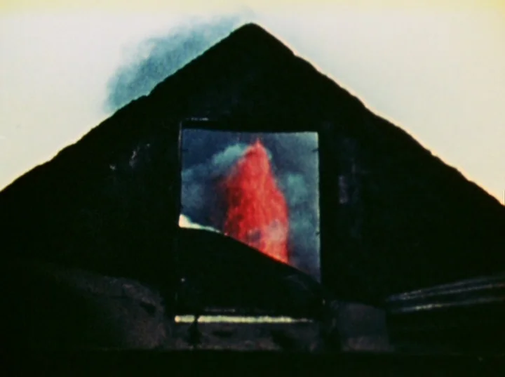 Lucifer Rising (1972) movie still: establishing — A dark, triangular mountain silhouette stands against a pale night sky. A square opening in the…