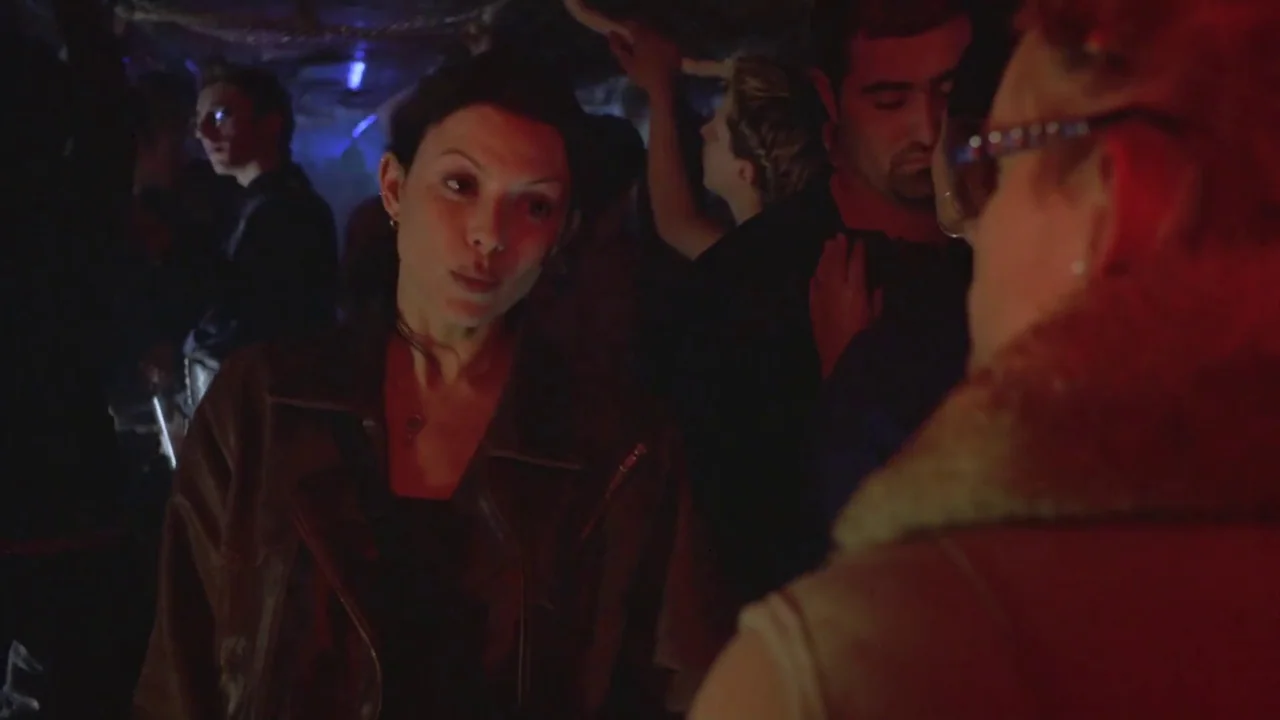Hellraiser: Deader (2005) movie still: medium — A dark, crowded nightclub interior filled with people in the dim background. A woman in a leather…