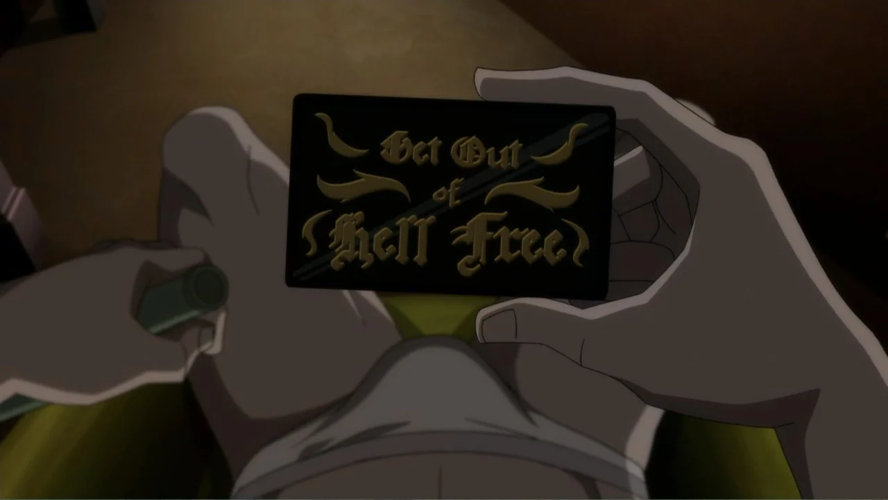 Suicide Squad: Hell to Pay (2018) movie still: closeup — A dimly lit room provides the backdrop for a close view of a card. Two hands hold a black…