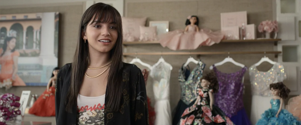 Father of the Bride (1991) movie still: medium — A well-lit retail boutique shop contains shelves of decorative dolls and formal dresses. A young…