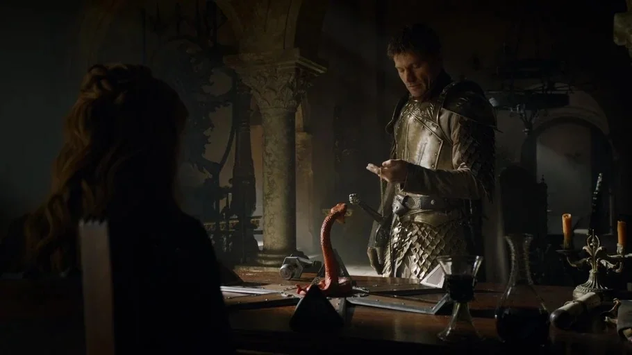 Game of Thrones (2015) movie still: medium — An dimly lit, ancient stone interior featuring large columns and a heavy wooden table. A armored knight…