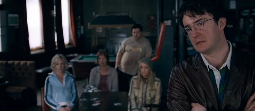 Shaun Of The Dead (2004) movie still: medium — A dimly lit pub features a pool table and several people sitting at tables. A man in the foreground…