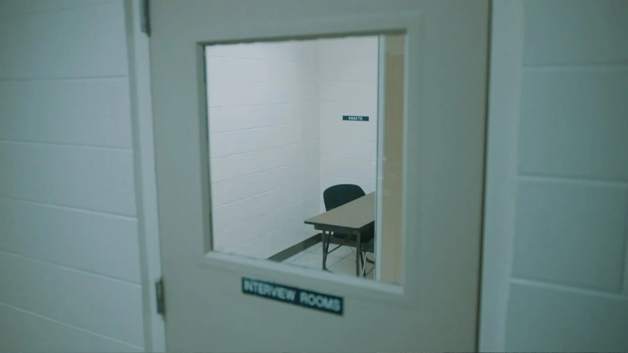 Aileen Wuornos : Mind of a Monster (2020) movie still: medium — An empty small room with white concrete block walls has a table and chair. A door…