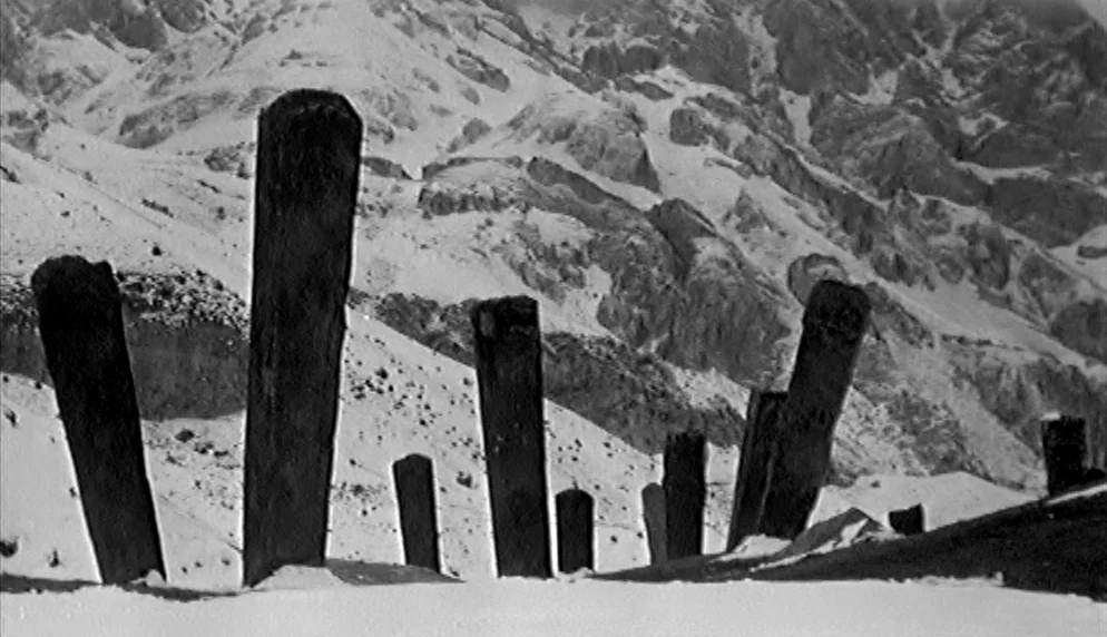The Plea (1968) movie still: wide — A snowy mountainside features several weathered vertical stones embedded in the frozen ground. The rugged peak…