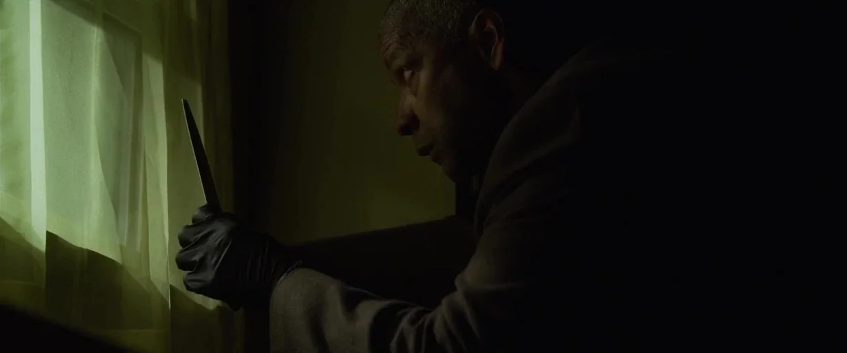 The Little Things (2021) movie still: medium — A dimly lit room features a window covered by thin white fabric curtains. A man wearing a black glove…