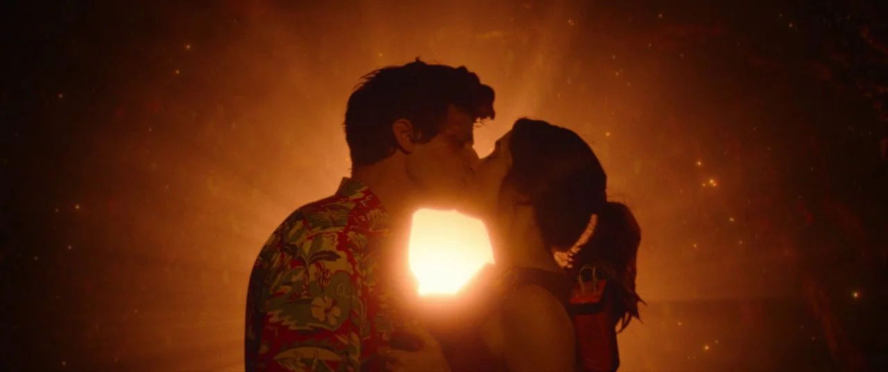 Palm Springs (2020) movie still: medium — A man and a woman stand together against a bright light source in an open area. They are silhouetted while…