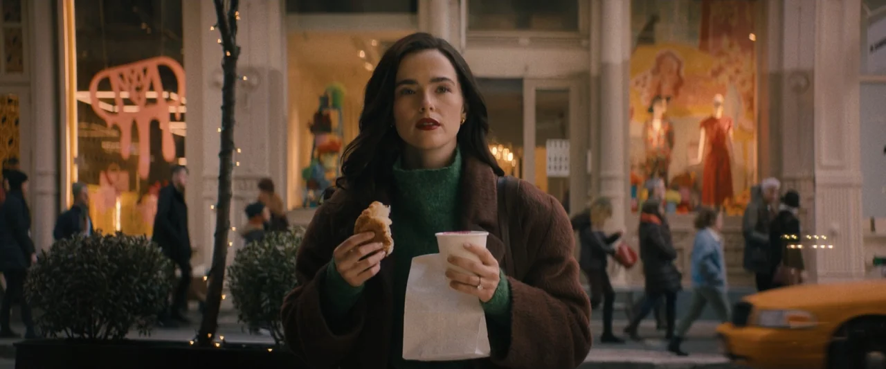 Something from Tiffany's (2022) movie still: medium — A busy urban sidewalk lined with storefronts and pedestrians during the early evening hours. A…