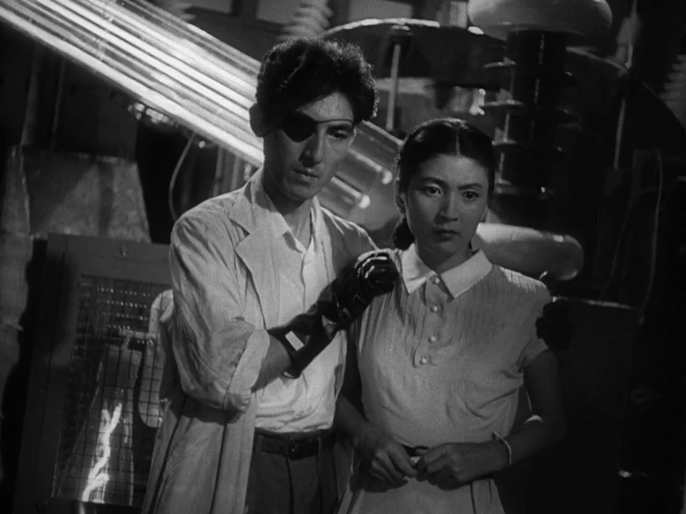 Godzilla (1954) (1954) movie still: medium — An industrial laboratory features large electrical apparatuses with glass tubes and metal components. A…