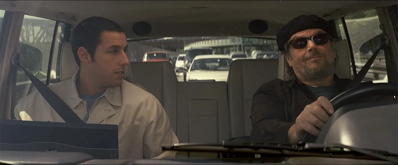 Anger Management (2003) movie still: medium — A view from inside a car moving through congested traffic on a highway. Two men sit in the front seats…
