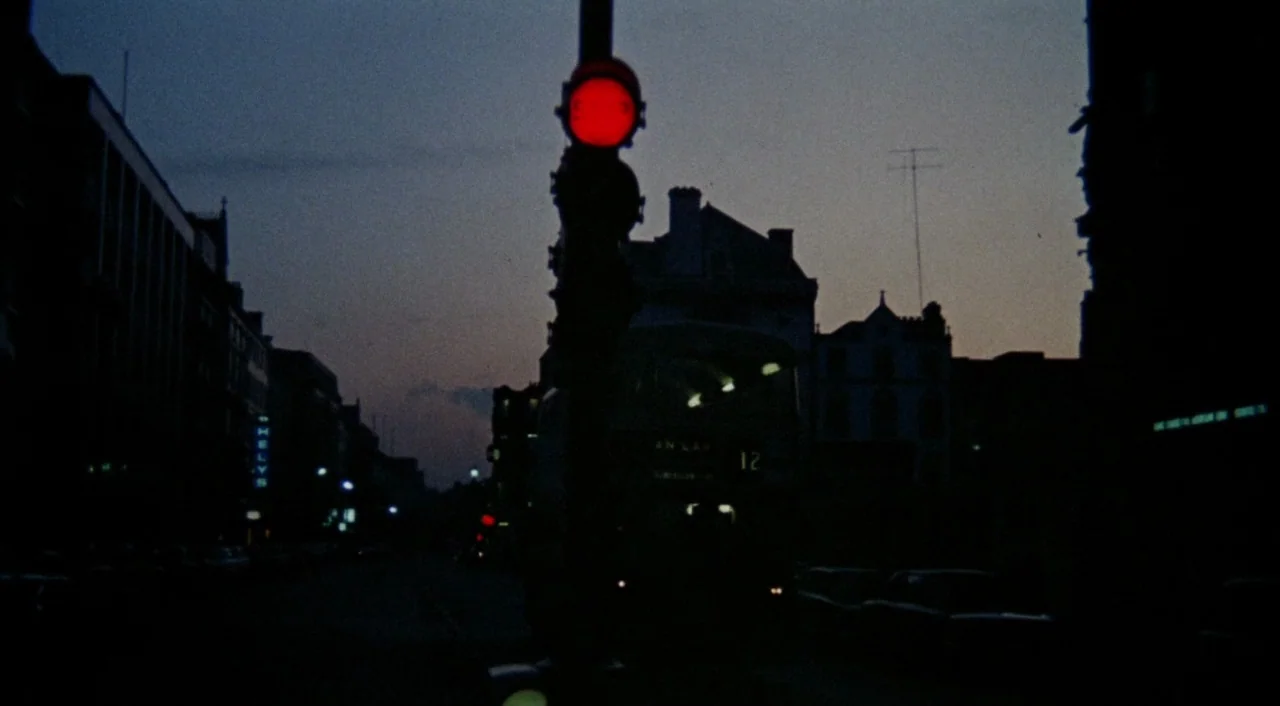The Iguana with the Tongue of Fire (1971) movie still: establishing — A city street at night is framed by dark silhouettes of multi-story buildings.…
