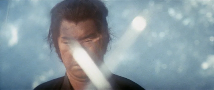 Lone Wolf and Cub: White Heaven in Hell (1974) movie still: closeup — A man stands outdoors surrounded by a bright, hazy, light-filled atmosphere. A…