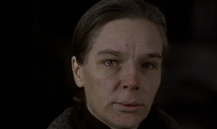 The Serpent’s Egg (1977) movie still: closeup — A close portrait of a woman against a dark, featureless background. She faces forward while soft…