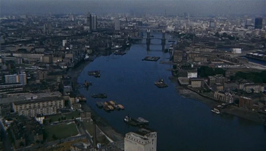 Frenzy (1972) movie still: establishing — An aerial view captures the Thames River winding through mid-century London with dense industrial…