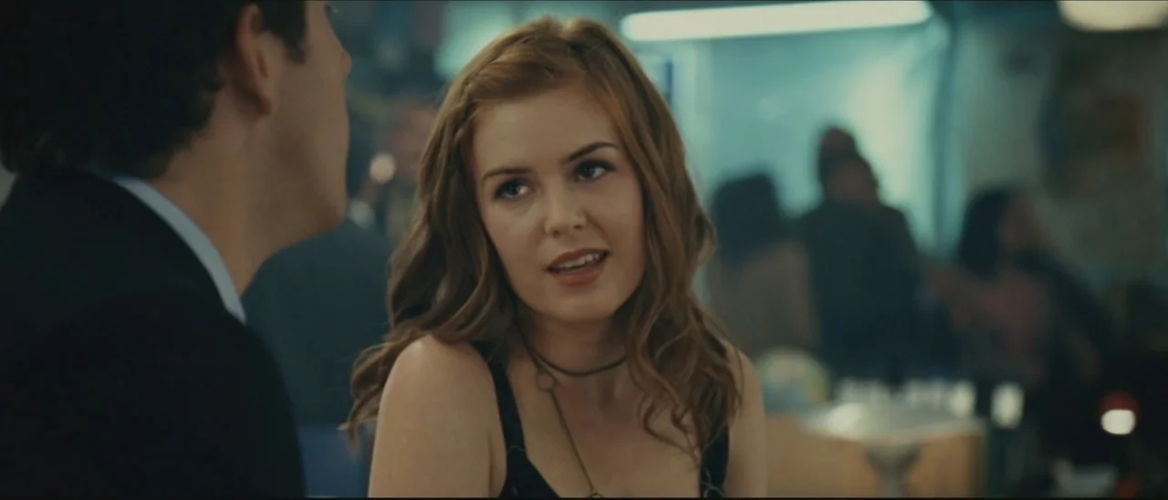 Definitely, Maybe (2008) movie still: medium — A crowded dimly lit social space contains several patrons in the blurred background. A man in a dark…