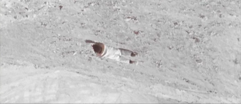 Django Kill (1967) movie still: wide — A vast expanse of textured white snow fills the frame. A single figure in white clothing lies horizontally in…