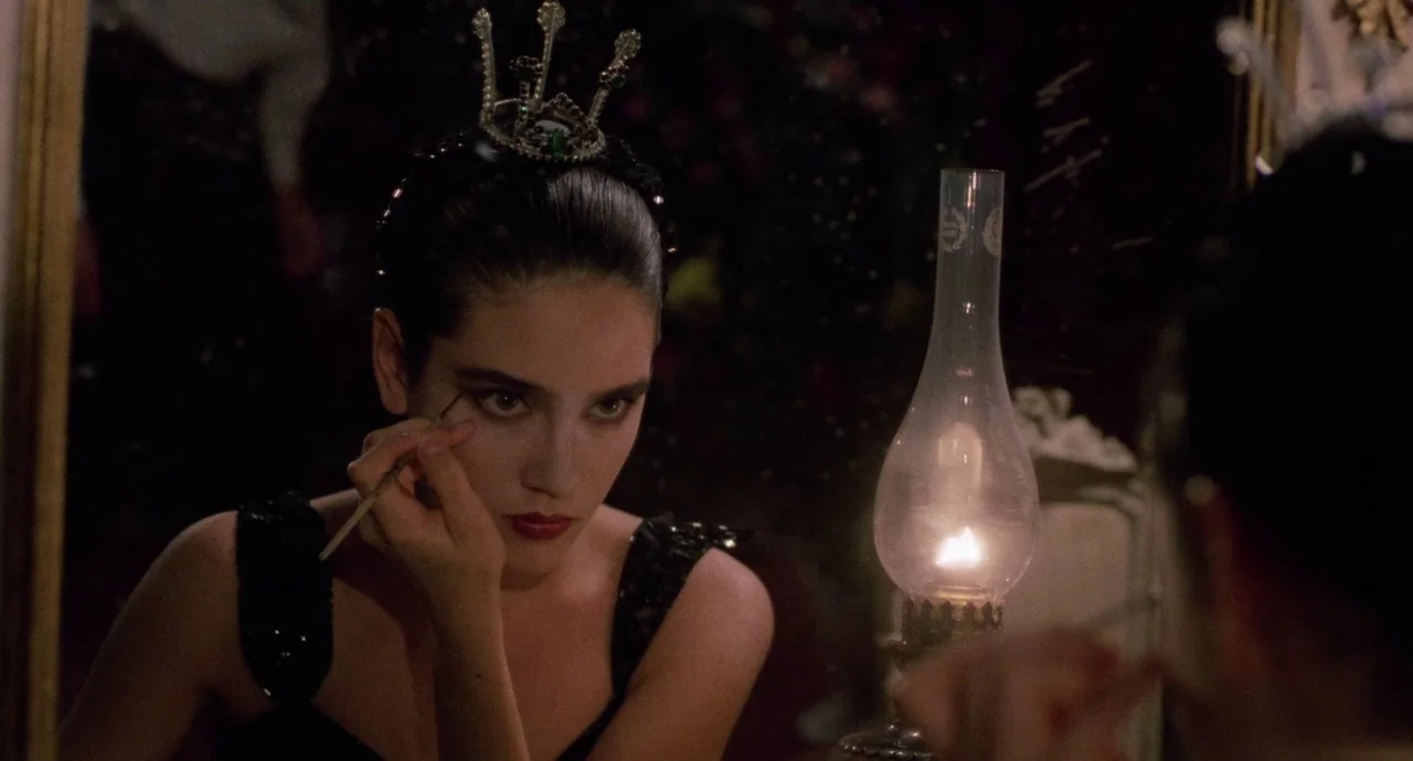 Etoile (1989) movie still: closeup — A dark space containing a vanity mirror reflecting a woman and an oil lamp. The woman looks into the mirror…