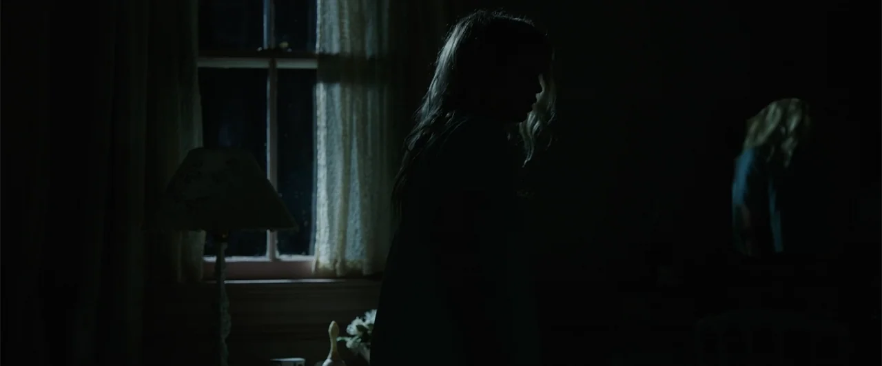 Annabelle: Creation (2017) movie still: medium — A dark, sparsely furnished room is lit primarily by moonlight filtering through a window. A lone…