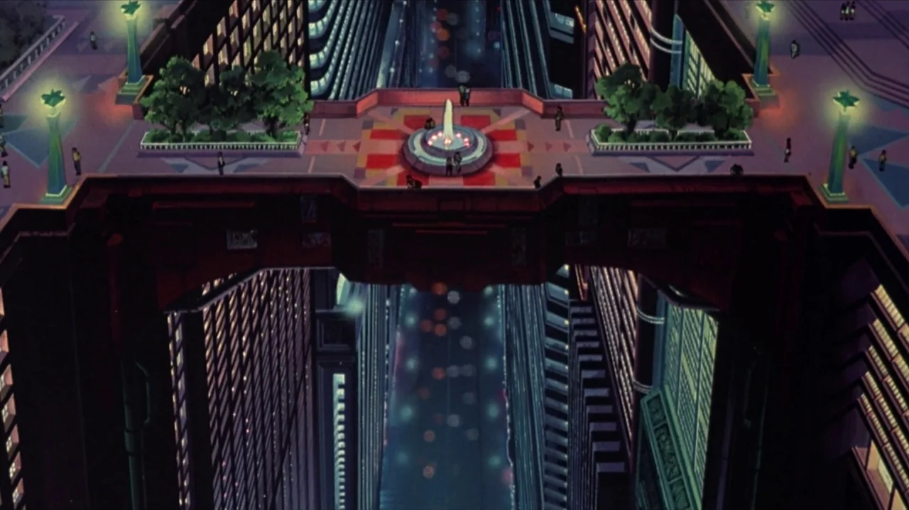 Akira (1988) movie still: establishing — A futuristic pedestrian skybridge crosses over a deep, dark canyon between two skyscrapers. A small…