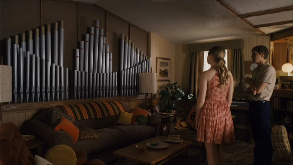 Youth In Revolt (2009) movie still: medium — A 1970s wood-paneled room features an array of organ pipes mounted on a wall. A young man and woman…