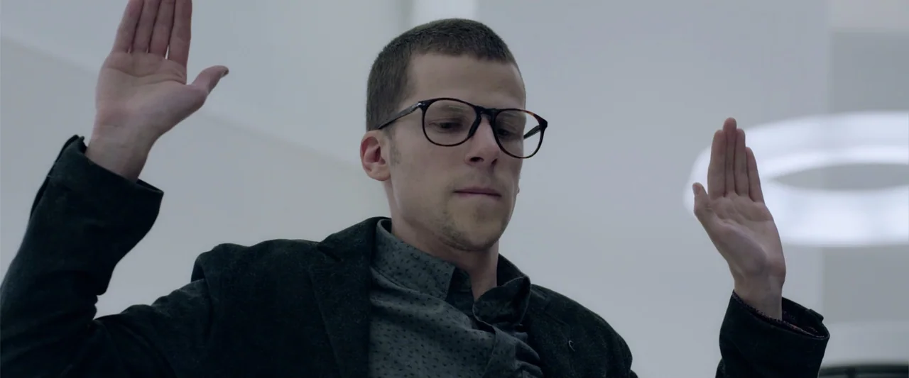 Now You See Me 2 (2016) movie still: medium — A stark white interior office space features minimalist architecture and bright lighting. A man stands…
