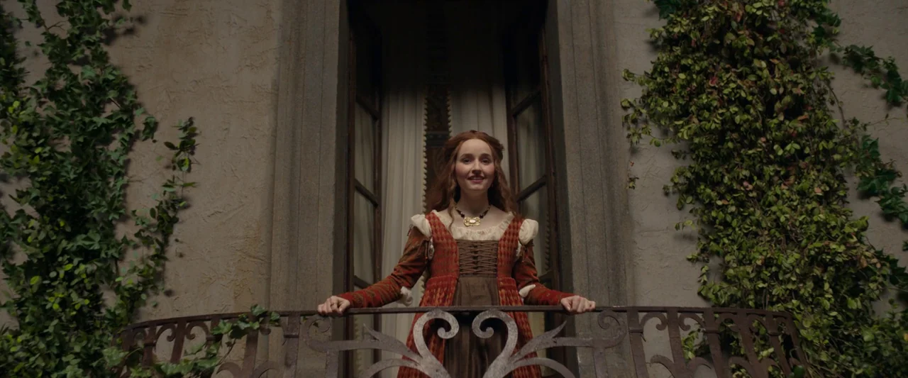 Rosaline (2022) movie still: medium — A stone balcony with ivy-covered walls provides an elevated vantage point. A young woman in a historical-style…