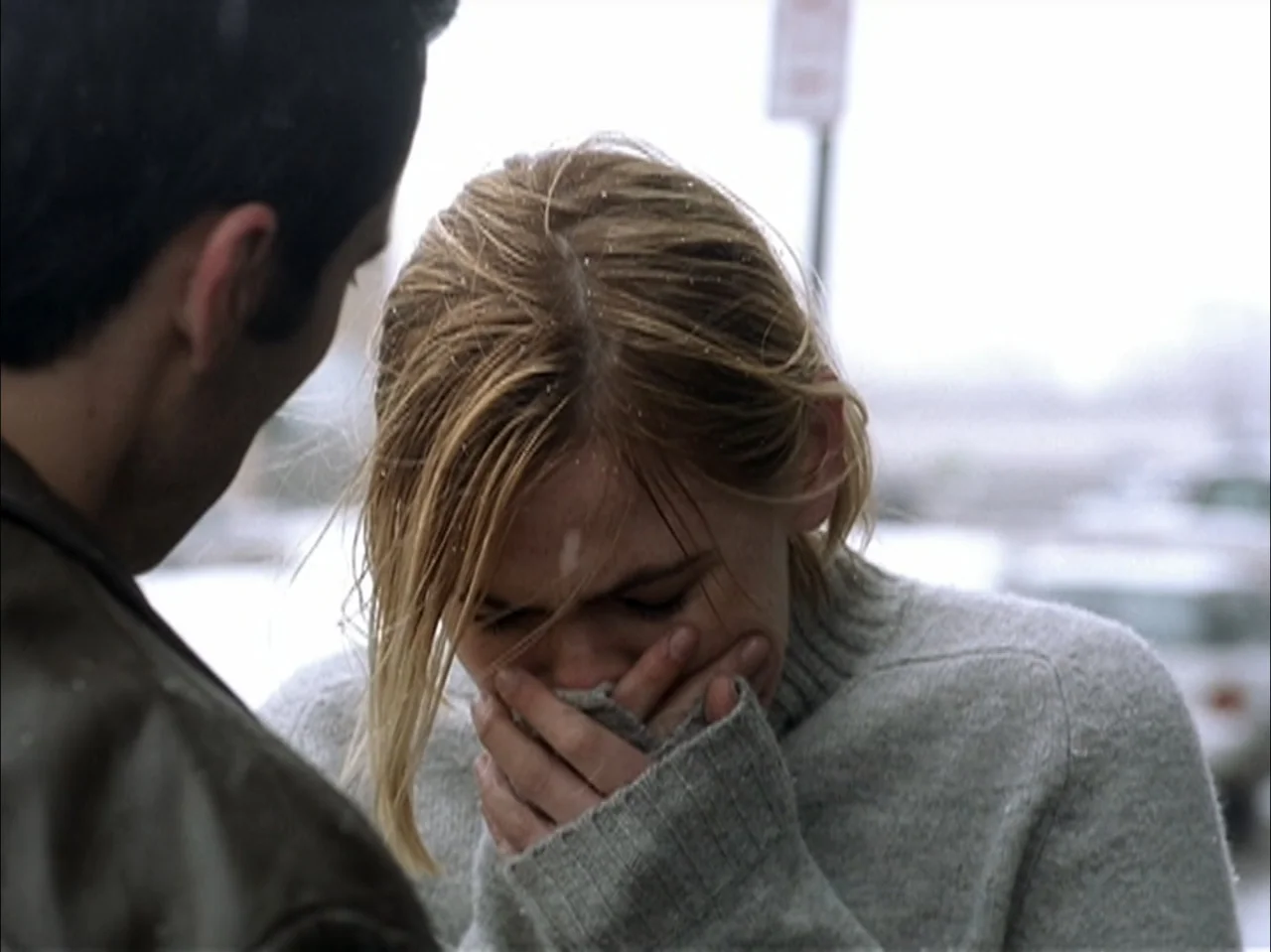 The Laramie Project (2020) movie still: medium — An outdoor location features a paved surface under a bright, overcast, snowy sky. A young woman…