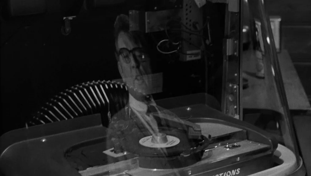 Who’s Afraid Of Virginia Woolf? (1966) movie still: medium — A vintage jukebox mechanism is visible with the reflection of a man superimposed over…