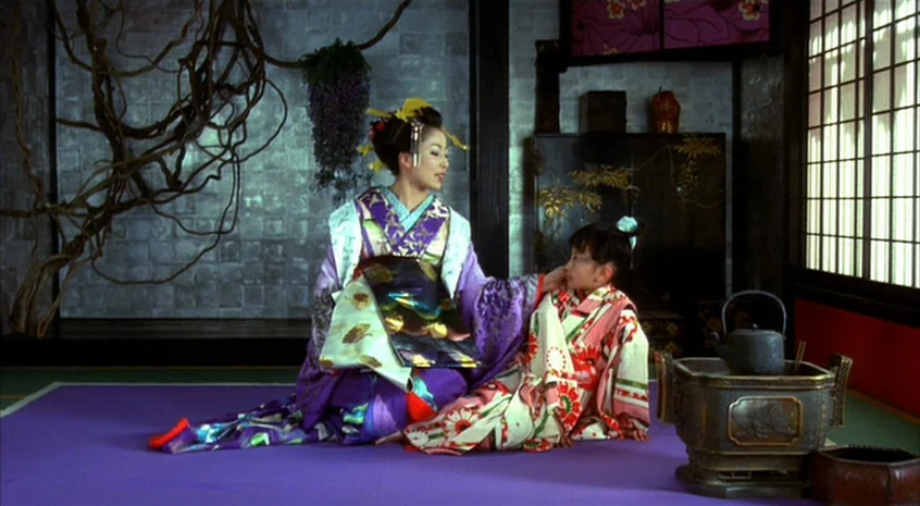 Sakuran (2006) movie still: fullbody — A traditional Japanese room features purple flooring and stylized dark tree branches on walls. A woman in a…