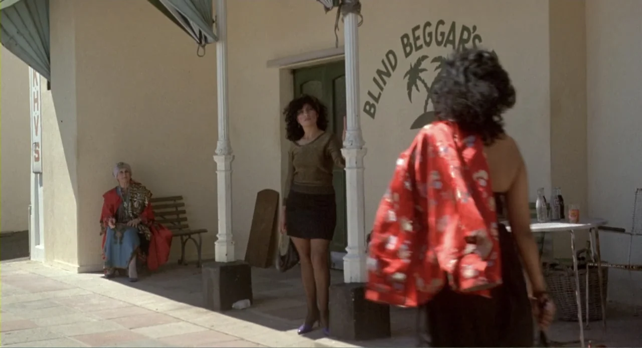 American Ninja 2: The Confrontation (1987) movie still: medium — An outdoor covered porch with a sign reading Blind Beggar's on the beige wall. One…