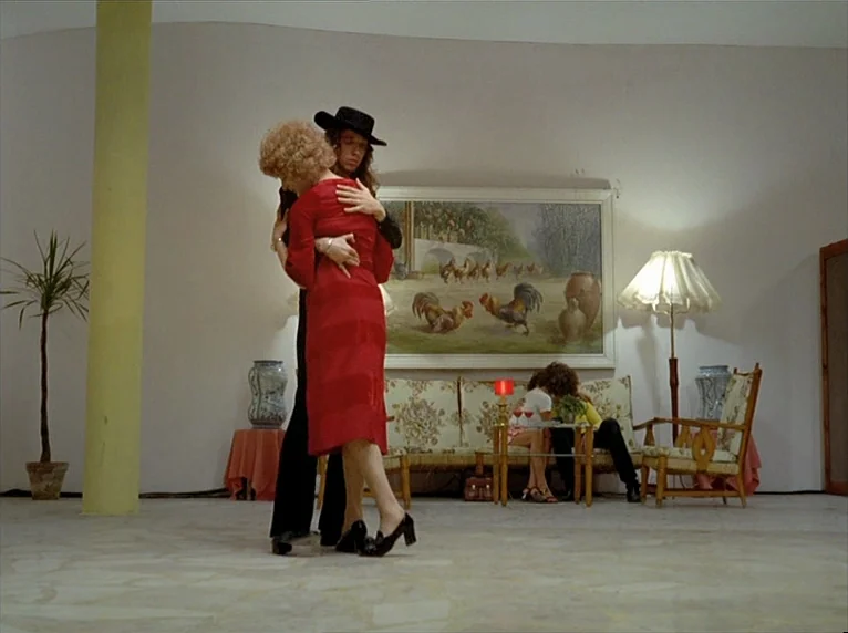 Beware Of A Holy Whore (1971) movie still: fullbody — A spacious room features white walls, a yellow pillar, and a large rooster painting. A man in…
