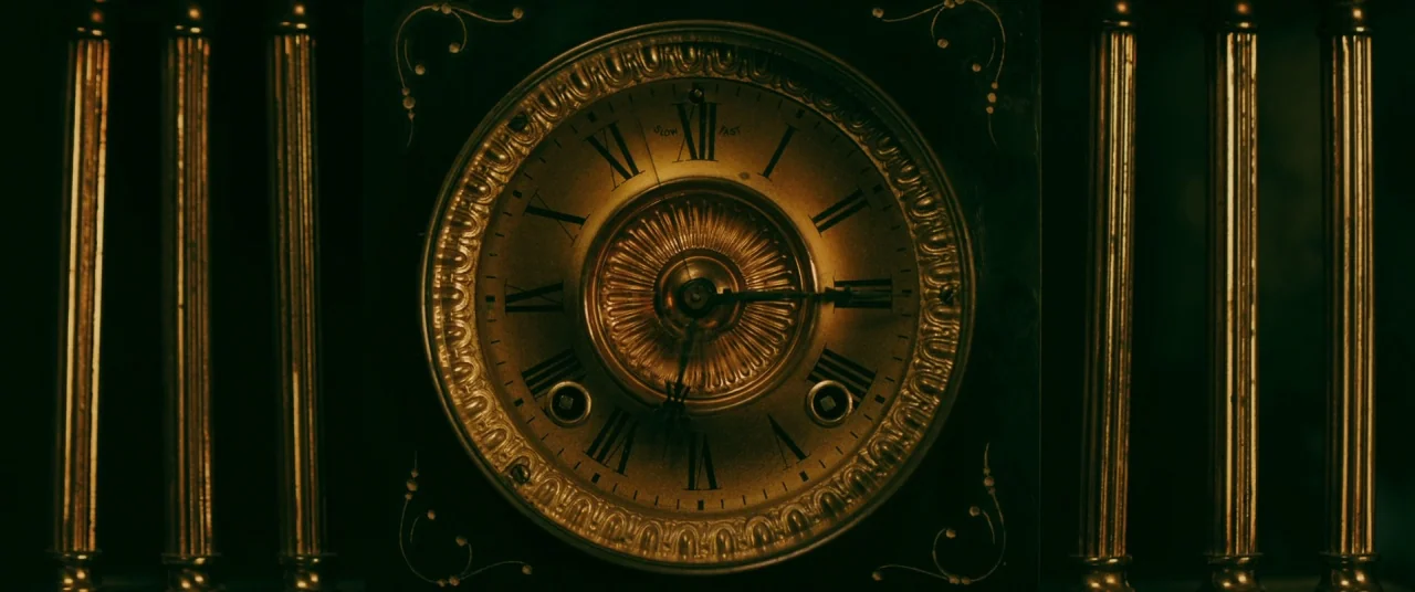 Ready or Not (2019) movie still: closeup — A close-up of a vintage ornate clock face with dark wooden trim and gold metal. The clock has Roman…