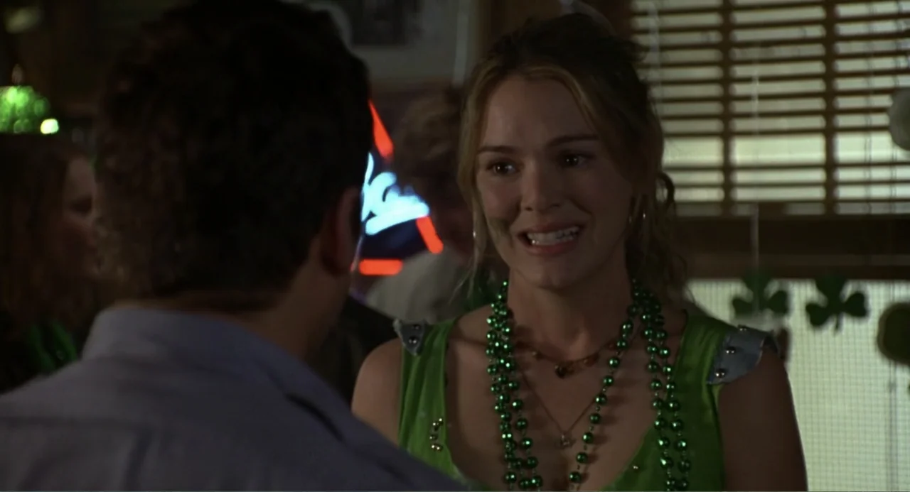 Ladder 49 (2004) movie still: medium — A dimly lit interior bar decorated with green shamrock cutouts for a holiday celebration. A woman in a green…