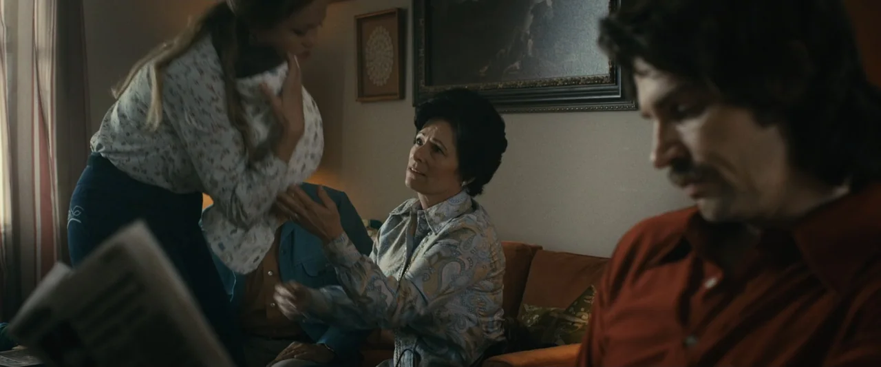 The Case for Christ (2017) movie still: medium — A 1970s living room features an orange couch, framed art, and patterned curtains. A middle-aged…