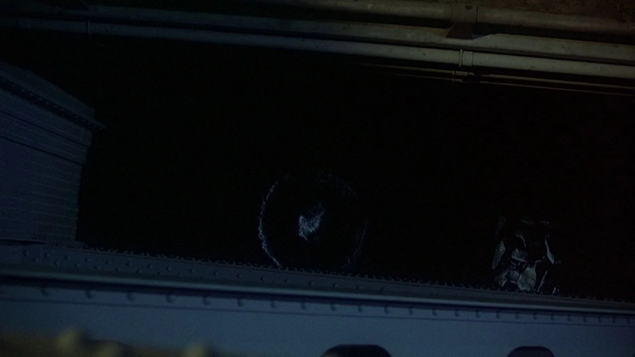 Saturday Night Fever (1977) movie still: wide — A dark, industrial bridge structure is visible at night against an empty black background. A faint…