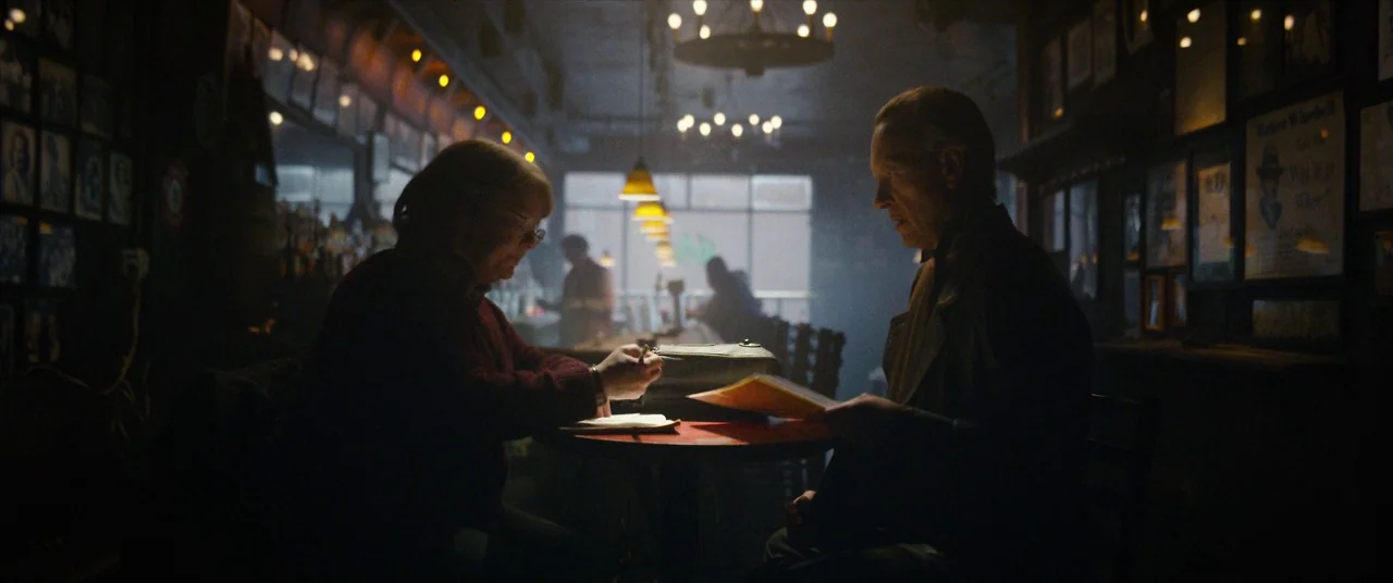 Can You Ever Forgive Me? (2018) movie still: medium — A dark, wood-paneled tavern with framed pictures on the walls and warm hanging pendants. Two…