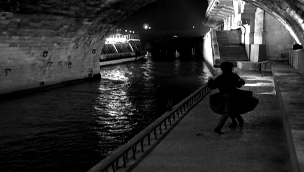 The Tango Lesson (1997) movie still: wide — A stone bridge spans a dark river at night with stone stairs nearby. A single person runs along the…