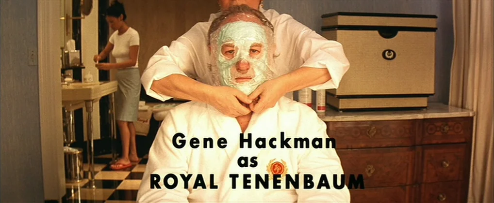 The Royal Tenenbaums (2001) movie still: medium — A well-appointed bathroom features checkered flooring and dark wood cabinets under a marble…