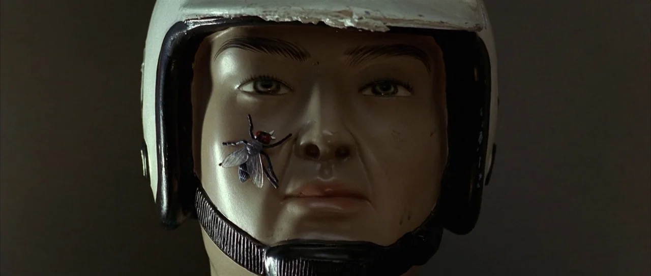 Sympathy for Mr. Vengeance (2002) movie still: closeup — A featureless mannequin head wears a white motorcycle helmet against a dark background. A…